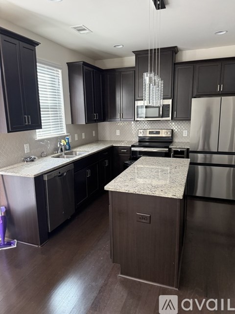 A kitchen with dark wood cabinets and stainless steel appliances.