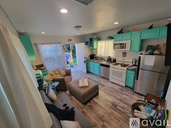 A kitchen with a refrigerator, oven, and sink.
