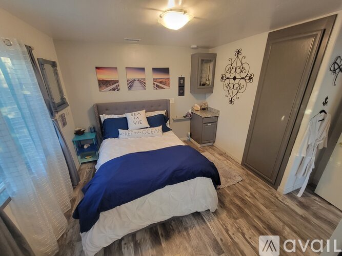 A bedroom with a bed, nightstand, and pictures on the wall.