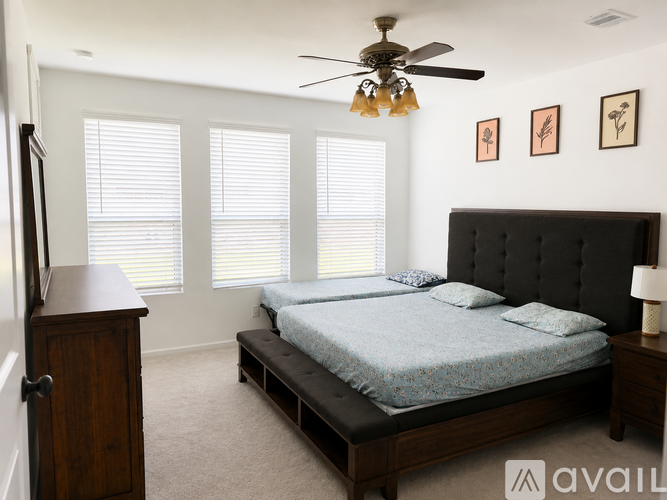 A bedroom with a large bed and a ceiling fan.