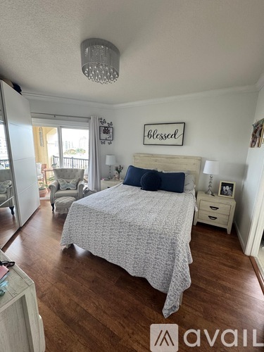 A bedroom with a bed, nightstand, and a chandelier.