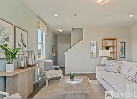 A living room with a white couch and a wooden coffee table.