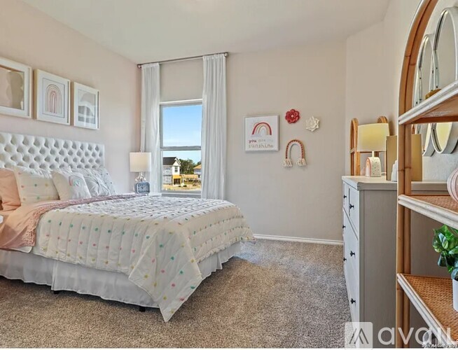 A bedroom with a large bed and a window with curtains.