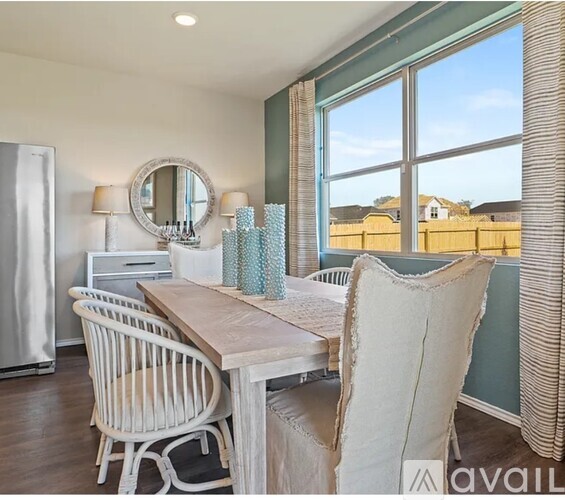 A dining room with a wooden table and chairs.