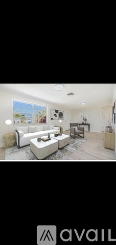 A modern living room with a white sofa and a wooden floor.