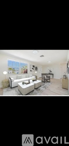 A modern living room with a white sofa and a wooden floor.