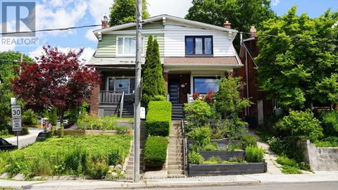 A house with a green lawn and a sign that says REALTOR.