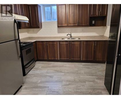 A kitchen with wooden cabinets and a tiled floor.