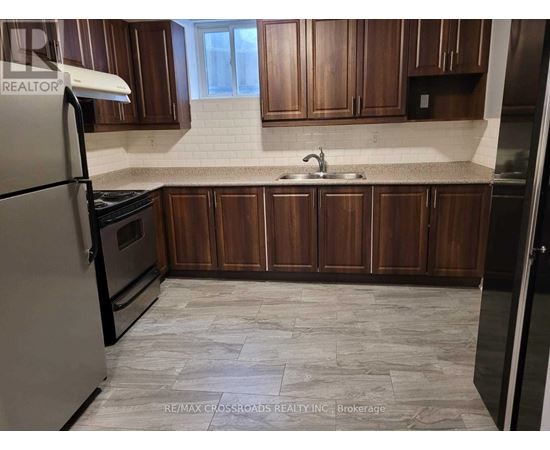 A kitchen with wooden cabinets and a tiled floor.