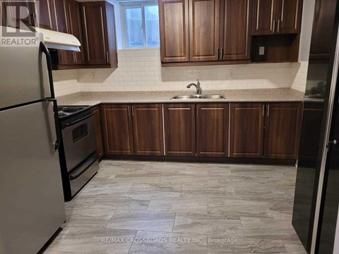 A kitchen with wooden cabinets and a tiled floor.