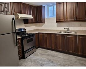 A kitchen with wooden cabinets and a white fridge.
