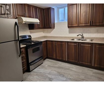 A kitchen with wooden cabinets and a white fridge.