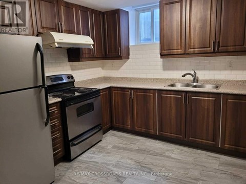 A kitchen with wooden cabinets and a white fridge.