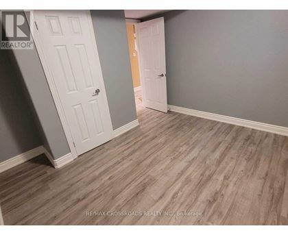A room with a wooden floor and two white doors.