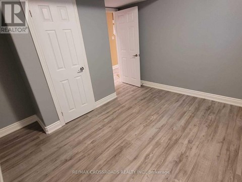 A room with a wooden floor and two white doors.