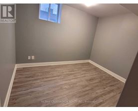 A room with wooden flooring and a window.