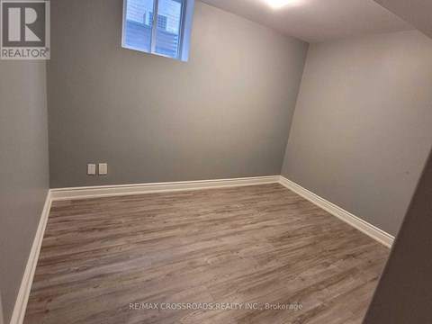 A room with wooden flooring and a window.