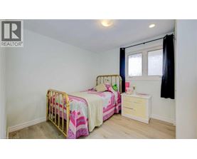 A bedroom with two beds and a nightstand.