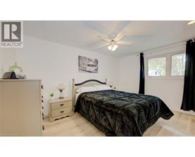 A bedroom with a bed, nightstand, and a dresser.