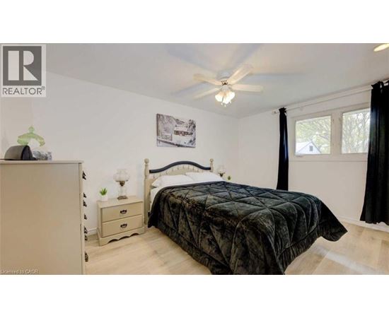 A bedroom with a bed, nightstand, and a dresser.
