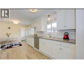A kitchen with white cabinets and a wooden floor.