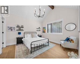 A bedroom with a large bed and a chandelier.