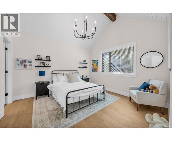 A bedroom with a large bed and a chandelier.