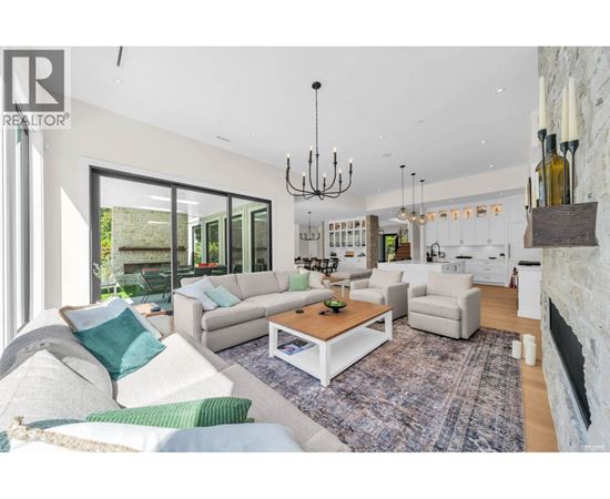 A living room with a white couch and a chandelier.