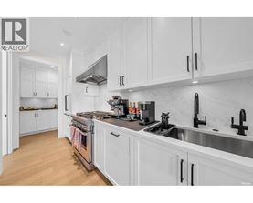 A modern kitchen with white cabinets and stainless steel appliances.