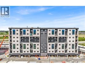 A large, multi-story building under construction with a clear blue sky above.