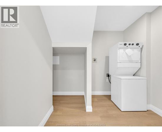 A white kitchen appliance sits in a corner of a white room.
