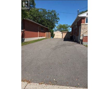 A driveway leads to a house with a garage.