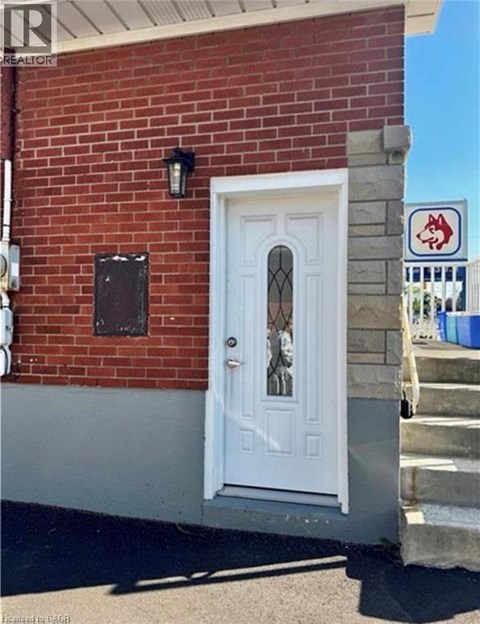 A white door is on a red brick building.