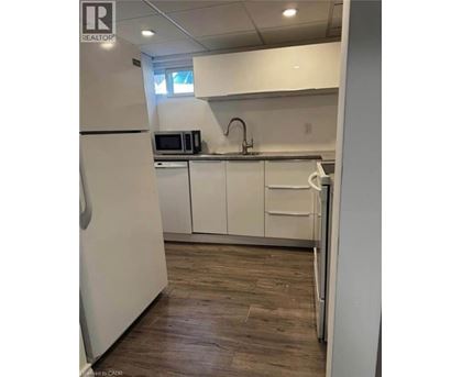 A kitchen with white cabinets and a wooden floor.