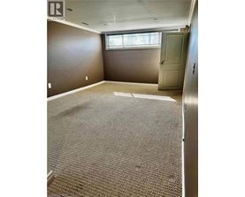 A room with a carpeted floor and a door.