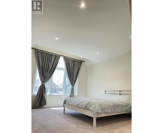 A bedroom with a bed, curtains, and a window.
