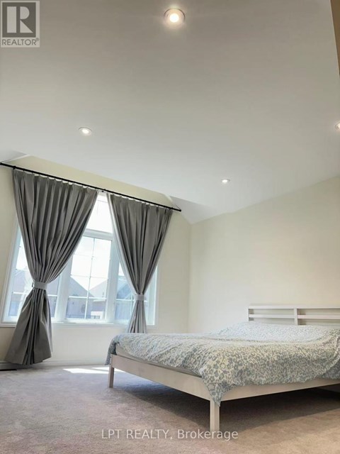 A bedroom with a bed, curtains, and a window.