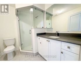 A white toilet sits next to a walk-in shower in a bathroom.
