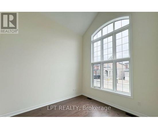 A room with a large window and a view of the street outside.