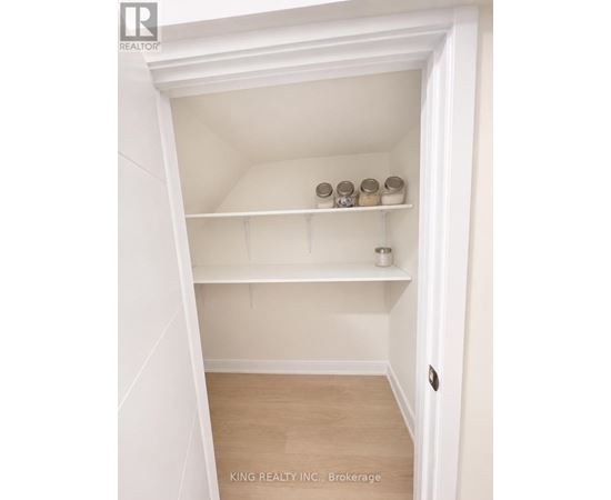 A white closet with shelves and a door.