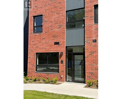 A red brick building with a black door and windows.