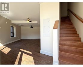 A room with a staircase and a ceiling fan.