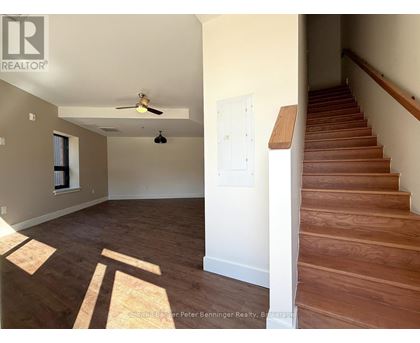 A room with a staircase and a ceiling fan.