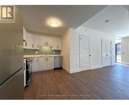 A kitchen with white cabinets and a wooden floor.