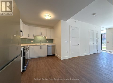 A kitchen with white cabinets and a wooden floor.
