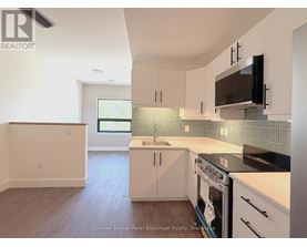 A kitchen with white cabinets and a black stove top oven.