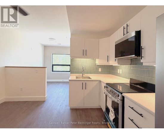 A kitchen with white cabinets and a black stove top oven.