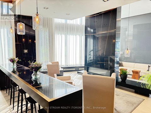 A modern living room with a glass table and a bar area.