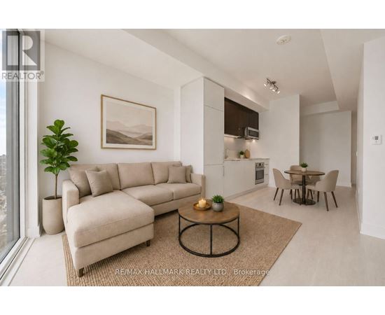 A living room with a beige sofa, a coffee table, and a dining table with chairs.