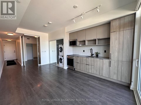 A spacious kitchen with wooden cabinets and a washing machine.